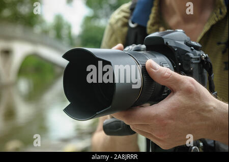 Le photographe se concentre. La main du photographe est de tourner la bague de mise au point de l'objectif. Banque D'Images