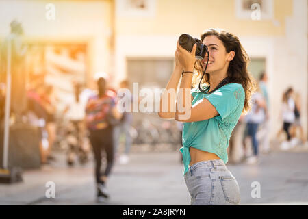 Photographe professionnel ou touristique de fille qui tire dans une ville. Banque D'Images