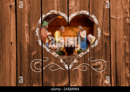 À l'intermédiaire d'un coeur en bois sculpté dans un mur de scène de la nativité en étable de Bethléem Banque D'Images