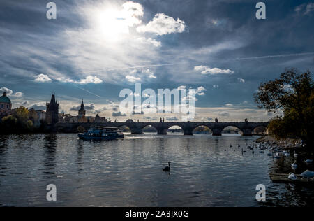 Le Pont Charles sur la rivière Moldova avec bateau et de cygnes dans Prague en République Tchèque Banque D'Images