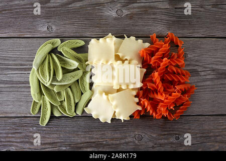 Spaghetti séchés dans les couleurs du drapeau italien sur fond de bois Banque D'Images