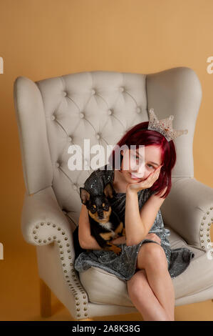 Beauty woman en studio. chihuahua. Nouvelle année session de photo d'une petite fille et un chien. Les cheveux rouges à l'adolescent. Black mini chihuahua. Ch Banque D'Images