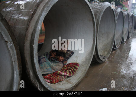 Les sans-abri abri dans un tuyau géant en raison de fortes pluies dans la région de Dhaka.Selon le Département météorologique du Bangladesh, le Cyclone Bulbul le compactage d'un vitesse du vent maximale de 120 kilomètres par heure (75 miles) est en passe de toucher terre près de les Sundarbans, la plus grande forêt de mangrove qui chevauche le Bangladesh et certaines parties de l'Inde. Banque D'Images