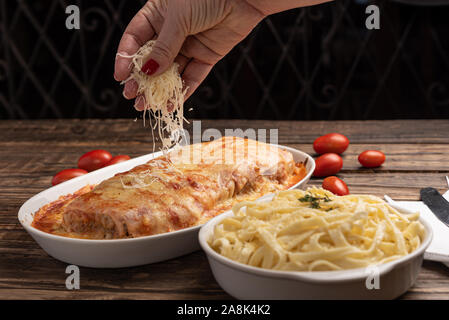Parmegiana Steak aussi connu que Filet Parmegiana avec des pâtes sur un fond de bois rustique, fromage et sauce tomate. Lumière douce Banque D'Images