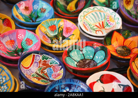 Des bols artisanaux peints colorés sont exposés sur un marché extérieur au Mexique, un tournesol bleu qui attire l'attention. Banque D'Images