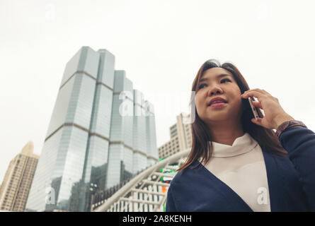 Businesswoman walking outdoor et talking on mobile phone Banque D'Images