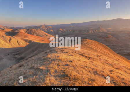 Photographe s'apprêtait à tourner dans les montagnes au coucher du soleil jour Banque D'Images