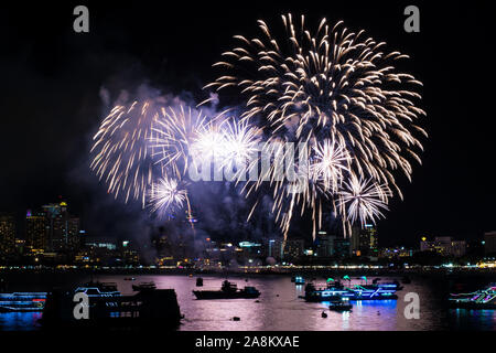 Of Fireworks par la plage et la mer entourant avec hôtels, restaurant, et les bateaux de service et des croisières pendant le temps de crépuscule bleu Banque D'Images