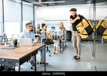 La prestation de repas frais de messagerie avec sac thermique pour un des employés de bureau. Concept de la distribution de vivres aux employés du bureau Banque D'Images