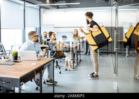 La prestation de repas frais de messagerie avec sac thermique pour un des employés de bureau. Concept de la distribution de vivres aux employés du bureau Banque D'Images