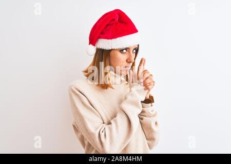 Belle rousse femme portant chapeau de Noël sur fond isolé avec des armes à feu symbolique Holding hand gesture, jouer à tuer les armes de tir, en colère Banque D'Images