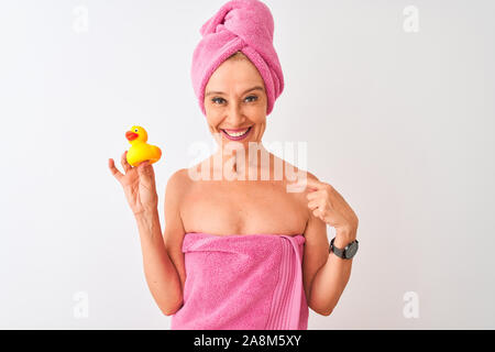 L'âge moyen femme portant serviettes holding toy canard sur fond blanc isolé avec surprise face à face à lui-même Banque D'Images