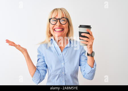 L'âge moyen businesswoman wearing glasses boire du café sur fond blanc isolé très heureux et excité, lauréat expression célébrant la victoire Banque D'Images