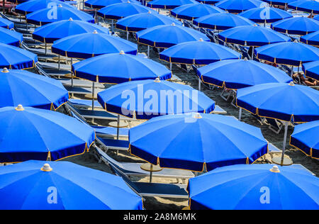 Des rangées de parasols et de chaises de plage bleus se trouvent à proximité et en partant du haut. Prise à Monterosso, en Italie, dans les Cinque Terre. Un exemple de symétrie great​. WOP Banque D'Images