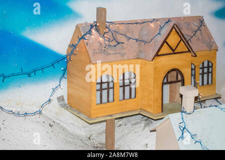 Maisons de noël faites de carton coupé avec de la neige artificielle avec des lumières de Noël Banque D'Images