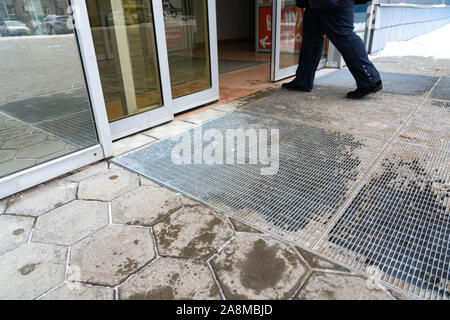 Yekaterinburg, Russie - Novembre 2019. Portes en verre automatique ouvrir et fermer. Entrée du centre commercial. L'hiver. Des empreintes humides sur le sol. Les jambes de ma Banque D'Images