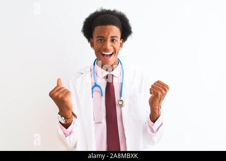 Young african american man wearing sthetoscope médecin isolé sur fond blanc célébration surpris et émerveillé pour le succès avec bras levés et Banque D'Images