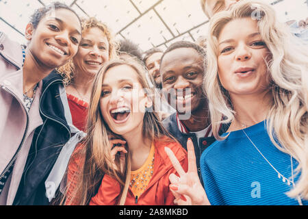 Les amis de différentes origines ethniques à la recherche dans l'appareil photo Banque D'Images