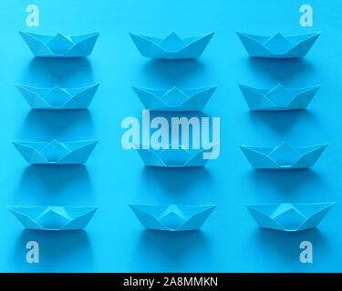 Close Up du vrai Origami Bateaux sur fond bleu Banque D'Images