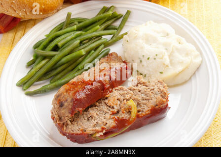 Vue supérieure de la maison de pain de viande en tranches servi avec une purée de pommes de terre et les haricots verts. L'accent sur le premier plan. Banque D'Images