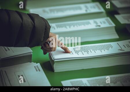 Barcelone, Espagne. 10 novembre, 2019 - L'électeur choisit le bulletin de son candidat dans un bureau de vote de Barcelone comme l'Espagne retourne aux urnes pour la quatrième élections générales en quatre ans pour essayer de mettre fin à l'impasse politique. Credit : Matthias Rickenbach/Alamy Live News Banque D'Images