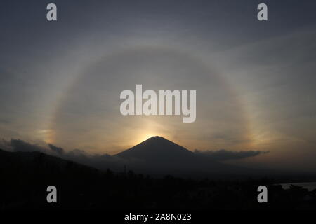 Un 22 ° halo est un phénomène optique qui appartient à la famille des halos de cristaux de glace. Effet de halo avant le coucher du soleil sur le volcan Agung à Bali, Indonésie. Banque D'Images