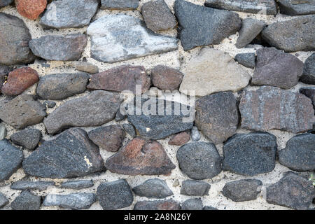 Un fragment d'un vieux mur de pierre faite de pierres brutes. L'arrière-plan. Gris. Banque D'Images