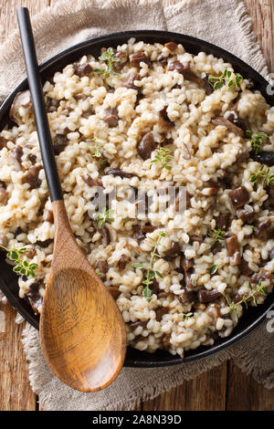 Recette de l'orge perlé Orsotto de forêt avec cèpes et le thym libre sur une plaque sur la table. Haut Vertical Vue de dessus Banque D'Images