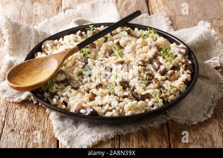 Orzotto en bonne santé de l'orge perlé cuit de withporcini les champignons sur une plaque horizontale sur la table. Banque D'Images