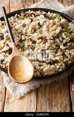 L'italien (Orzotto perlotto) aux cèpes et le thym libre sur une plaque sur la table verticale. Banque D'Images