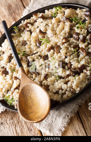 Orzotto sain aux cèpes et le thym libre sur une plaque sur la table verticale. Banque D'Images