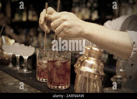 Barman est en remuant des cocktails sur comptoir bar Banque D'Images