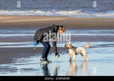 Southport, Royaume-Uni. 10 novembre 2019. Après une semaine de pluie continue, le soleil perce enfin comme des personnes de sortir de l'amusement au soleil sur une journée froide crisp sur la plage de Southport Merseyside. Credit : Cernan Elias/Alamy Live News Banque D'Images