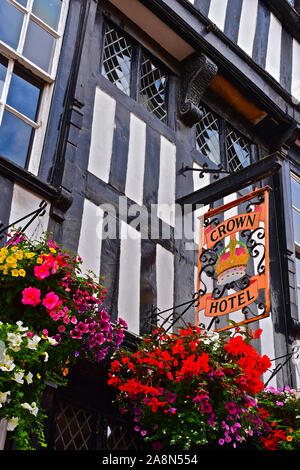 Une vue rapprochée de l'enseigne de pub à l'extérieur de l'Hôtel de la Couronne du 16e siècle. Bâtiment à colombages et vieilles fenêtres à petits carreaux. Paniers de fleurs colorées. Banque D'Images