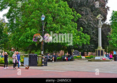 Une vue sur la rue de la jolie place de la ville dans le centre de la ville historique de Nantwich. War Memorial est un point focal. Shoppers assis sur des bancs. Banque D'Images