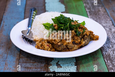 Sauté de porc riz avec des feuilles de basilic et mettre l'oeuf préservé. Banque D'Images