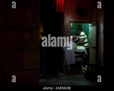 Mumbai, Inde - octobre 28,2019 : Planche Homme' Indian man ironing clothes pour vivre au sud de Mumbai Banque D'Images