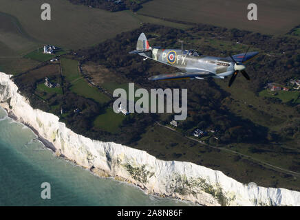 Un Spitfire de la Seconde Guerre mondiale, survole les falaises blanches de Douvres, dans le Kent, dans un hommage à la tombée du jour du Souvenir. Banque D'Images