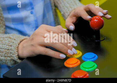 Gamer femme mains jouer jeu machine arcade rétro et en poussant les boutons lumineux Banque D'Images