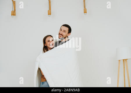 Portrait d'un heureux couple d'âge moyen enroulés dans une couverture Banque D'Images