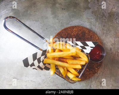 Frites en carton un scoop.Les frites dans le panier avec le ketchup et la sauce rustique isolé sur fond gris. concept sain .perdre du poids backg Banque D'Images
