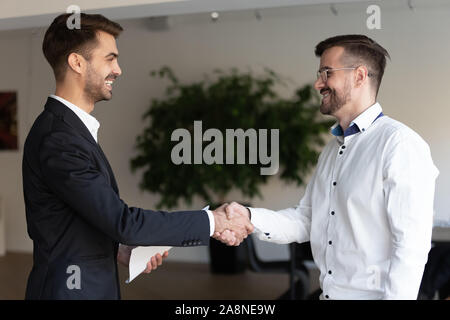 Smiling businessmen handshake se familiariser dans office Banque D'Images