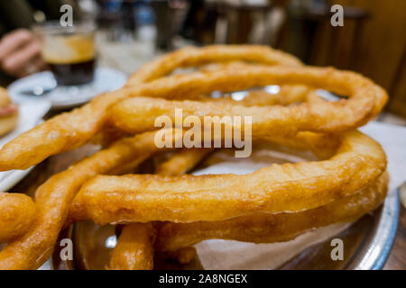 Close up de quelques Churros (Porra) sur une plaque blanche, sans sucre ajouté. L'Andalousie, espagne. Banque D'Images