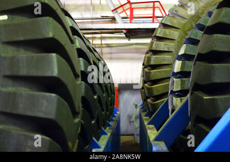 Entrepôt avec pneus pour camions à une installation industrielle pour la production de voitures. Le protecteur d'une grande roue en caoutchouc. Rouleau en caoutchouc de la benne. Banque D'Images