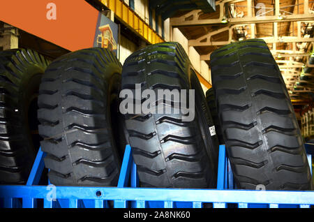 Entrepôt avec pneus pour camions à une installation industrielle pour la production de voitures. Le protecteur d'une grande roue en caoutchouc. Rouleau en caoutchouc de la benne. Banque D'Images