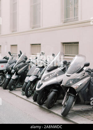 Les motos et scooters garés dans une rangée sur un trottoir à Paris, France Banque D'Images