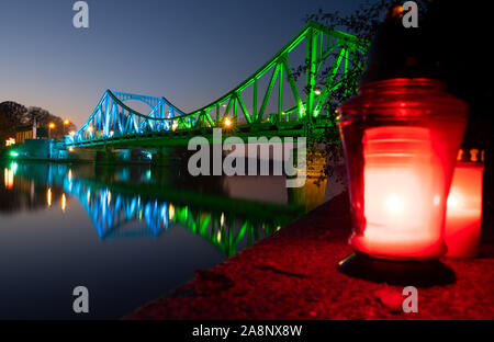 Berlin, Allemagne. 10 Nov, 2019. Le Pont de Glienicke est allumé de fête peu après le coucher du soleil à l'occasion du 30e anniversaire de la chute du mur, alors que les deux voyants sont graves sur les rives de la Havel. Avec un événement festif dans la Nikolaikirche et une commémoration de la Glienicker Bridge, le parlement de l'état et de gouvernement de l'état de commémorer l'ouverture de la frontière entre Potsdam et Berlin il y a 30 ans. Credit : Monika Skolimowska/dpa-Zentralbild/dpa/Alamy Live News Banque D'Images