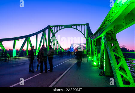 Berlin, Allemagne. 10 Nov, 2019. Le Pont de Glienicke est illuminé de fête peu après le coucher du soleil à l'occasion du 30e anniversaire de la chute du mur (photo avec une longue exposition). Avec un événement festif dans la Nikolaikirche et une commémoration de la Glienicker Bridge, le parlement de l'état et de gouvernement de l'état de commémorer l'ouverture de la frontière entre Potsdam et Berlin il y a 30 ans. Credit : Monika Skolimowska/dpa-Zentralbild/dpa/Alamy Live News Banque D'Images