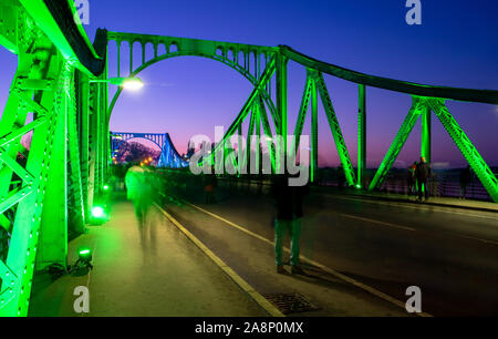 Berlin, Allemagne. 10 Nov, 2019. Le Pont de Glienicke est illuminé de fête peu après le coucher du soleil à l'occasion du 30e anniversaire de la chute du mur (photo avec une longue exposition). Avec un événement festif dans la Nikolaikirche et une commémoration de la Glienicker Bridge, le parlement de l'état et de gouvernement de l'état de commémorer l'ouverture de la frontière entre Potsdam et Berlin il y a 30 ans. Credit : Monika Skolimowska/dpa-Zentralbild/dpa/Alamy Live News Banque D'Images