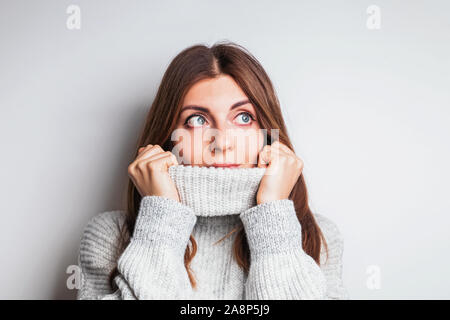 Femme dans un pull en laine confortable avec un sourire amical à côté Banque D'Images